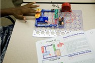 A student tests a circuit board.