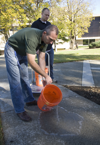 Assistant Professor John Kevern and Chris Farney, a Civil Engineering graduate student, perform an infiltration test for water absorbency.