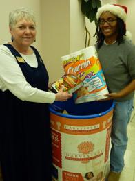 Pat Payne, administrative assistant, and Tracey Hughes, Dental Instructional Resources Librarian, contribute to Miller Nichols Library's Harvesters food drive.