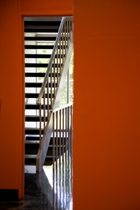Katz Hall's reception area features a bright orange accent wall and furniture characteristic of the mid-century modern era.