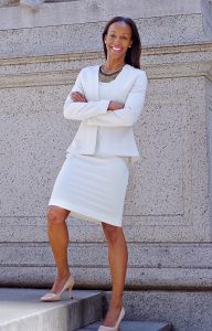 Sarah Lewis stands in white suit in front of a statue