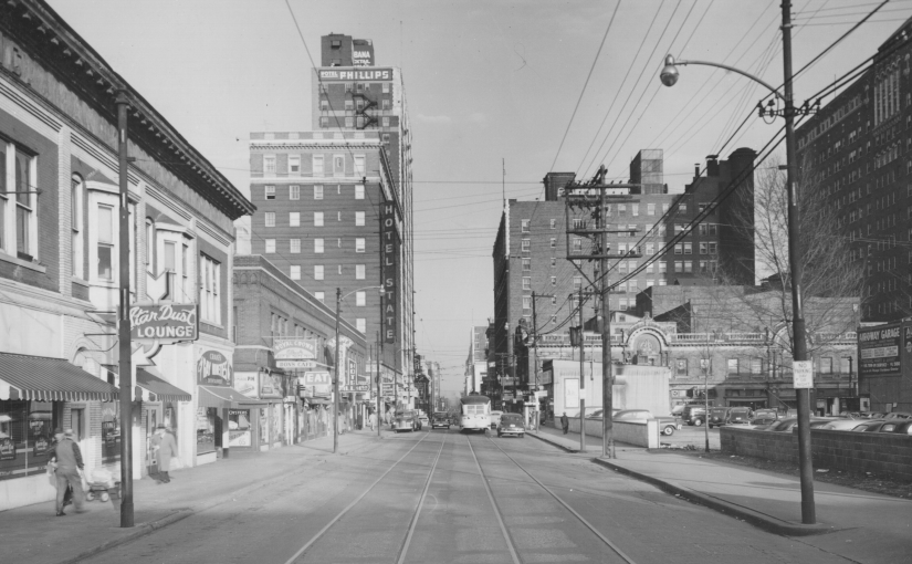 Black and white street view of downtown Kansas City, with the State Hotel visible on the left.
