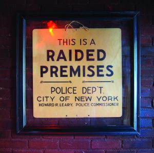 Framed sign that reads "This is a raided premises. Police dept, City of New York."