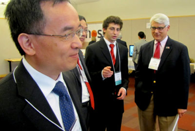 Michael Song, left, IEI executive director, Bloch School Dean Teng-Kee Tan, and Bank of Blue Valley President Bob Regnier (far right) talk with a student showcasing at VCC.