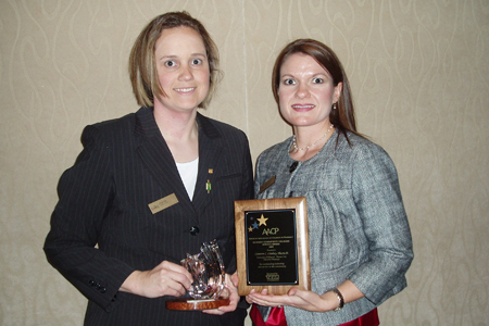 Kristin Fish, Pharmacy Student (left) and Dr. Cameron Lindsey (right) accept the award for their work in the Patient Assistance Program. Other student members of the project included Michelle Campbell, Kara Miller, Danielle Nagel and Cassie Peters.