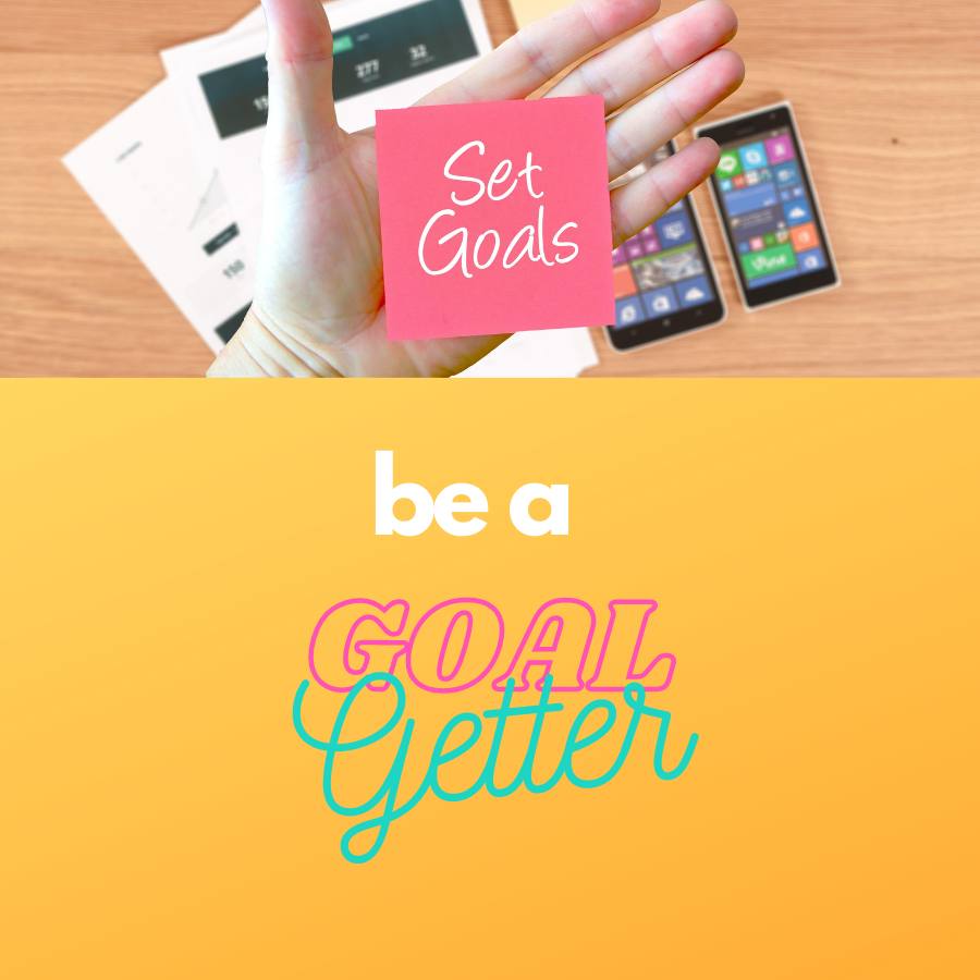 hand holding a post-it note "set goals" and "be a goal getter"